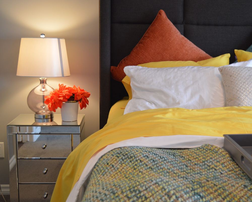 Dormitori decorat amb colors càlids, tauleta de mirall i làmpada